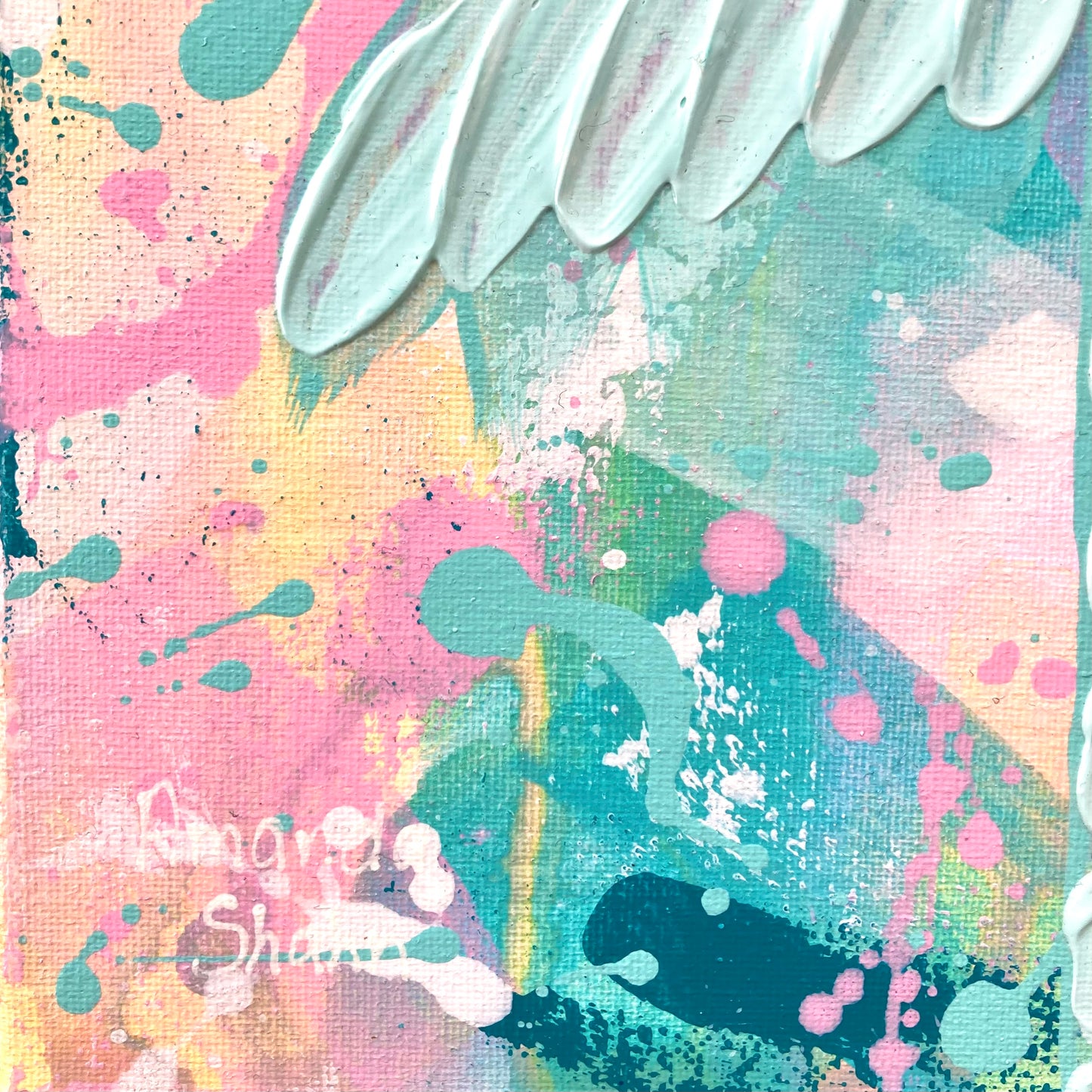 Up close view of the artist's signature against a colourful abstract background