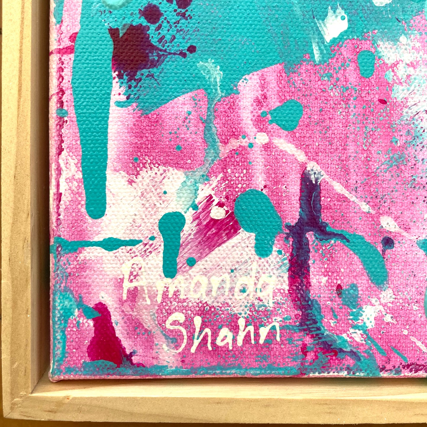 Close up shot of Dreaming Under The Palms showing the artist's signature against an abstract pink and aqua background